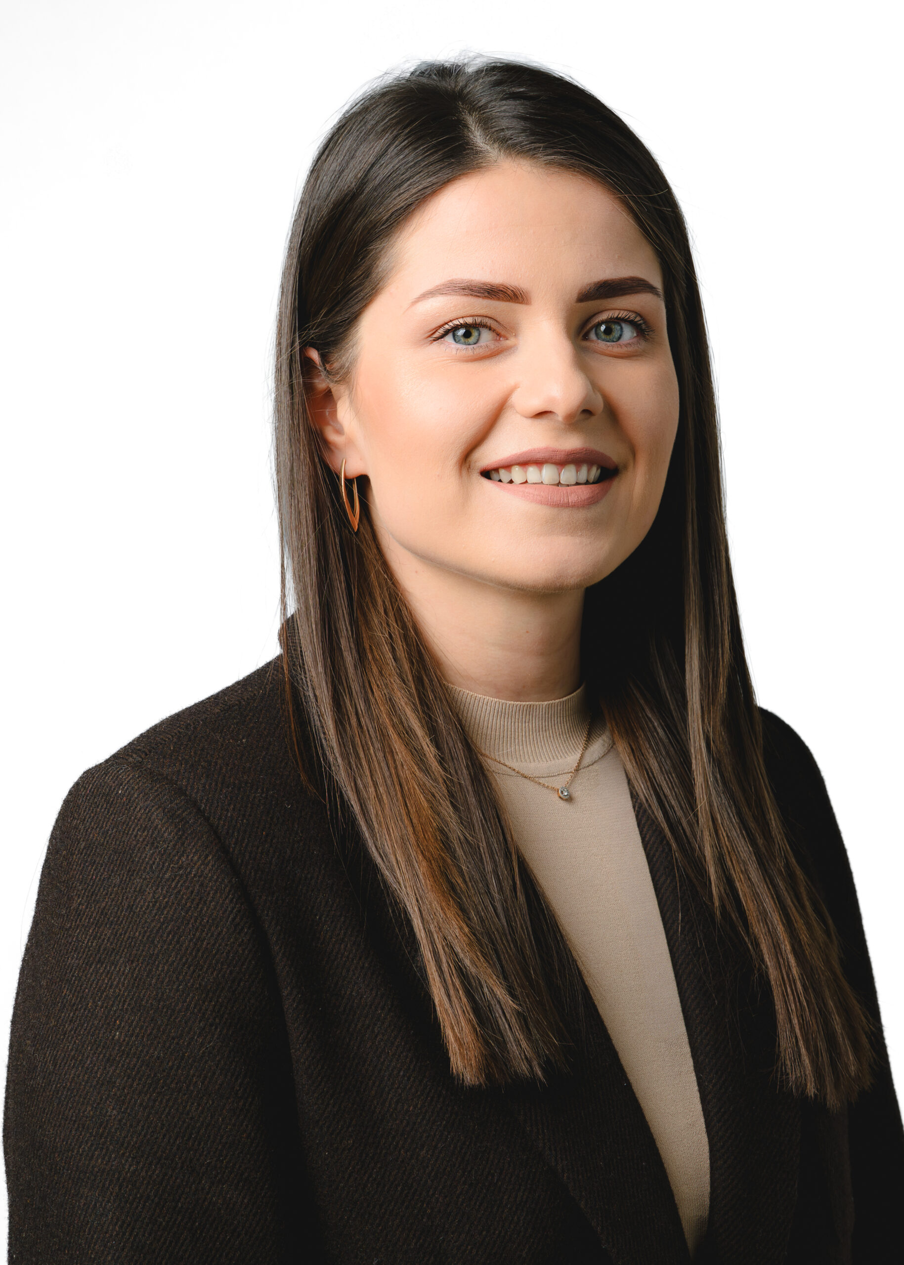 Professional woman with long brown hair in business attire smiles confidently.